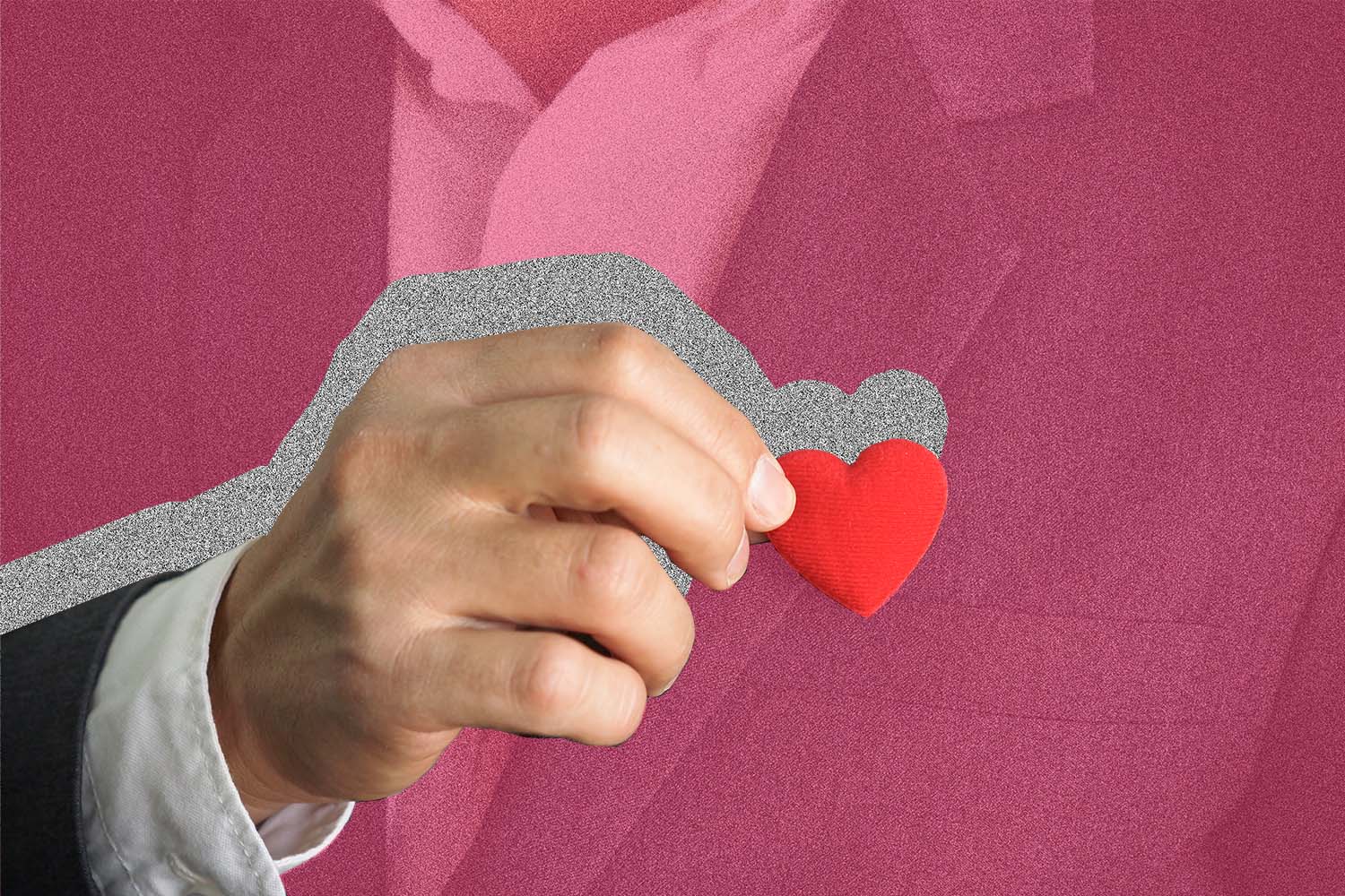 Man in suit holds tiny heart.