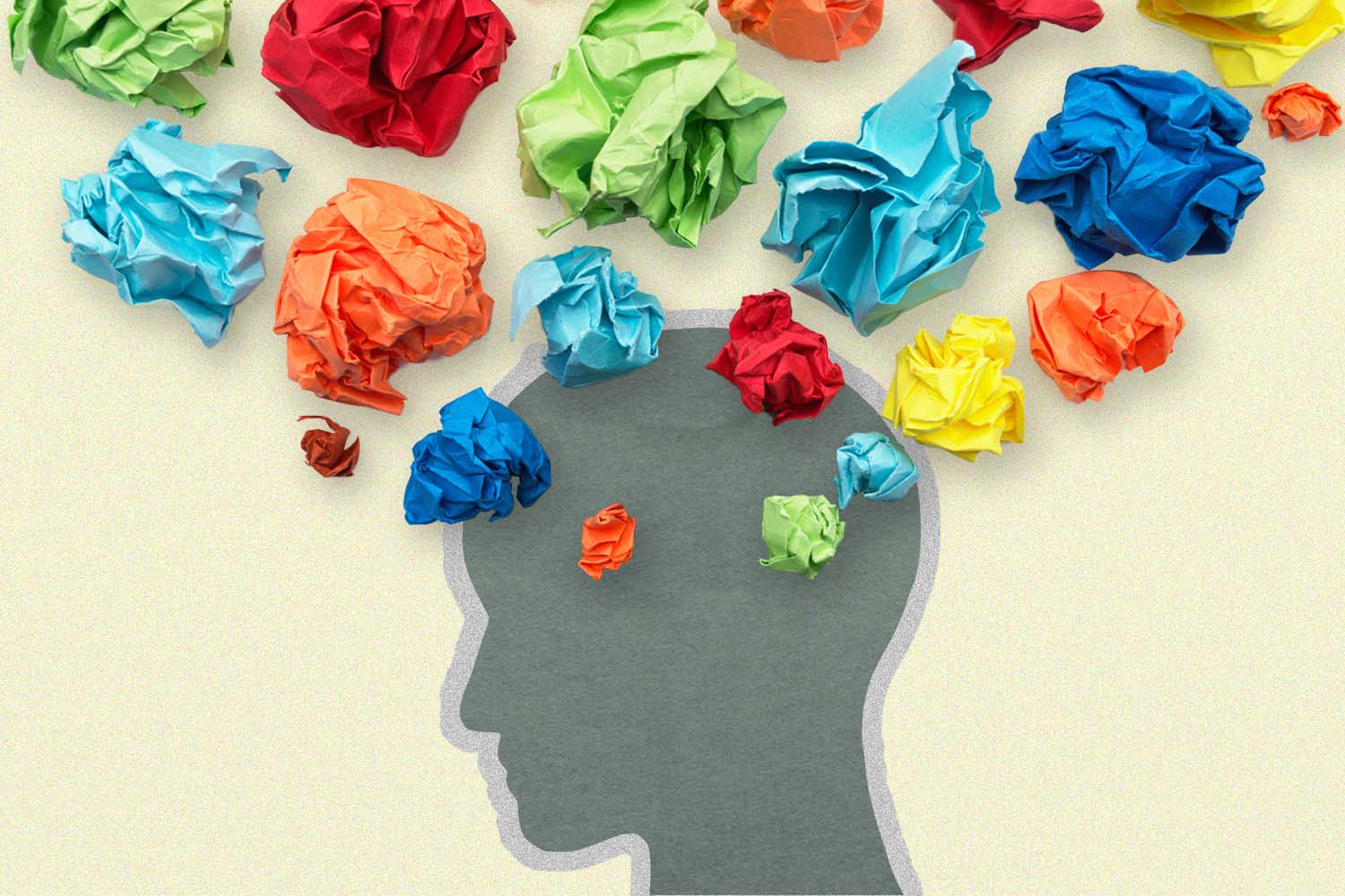Cutout of a face, with colorful crumpled paper on top