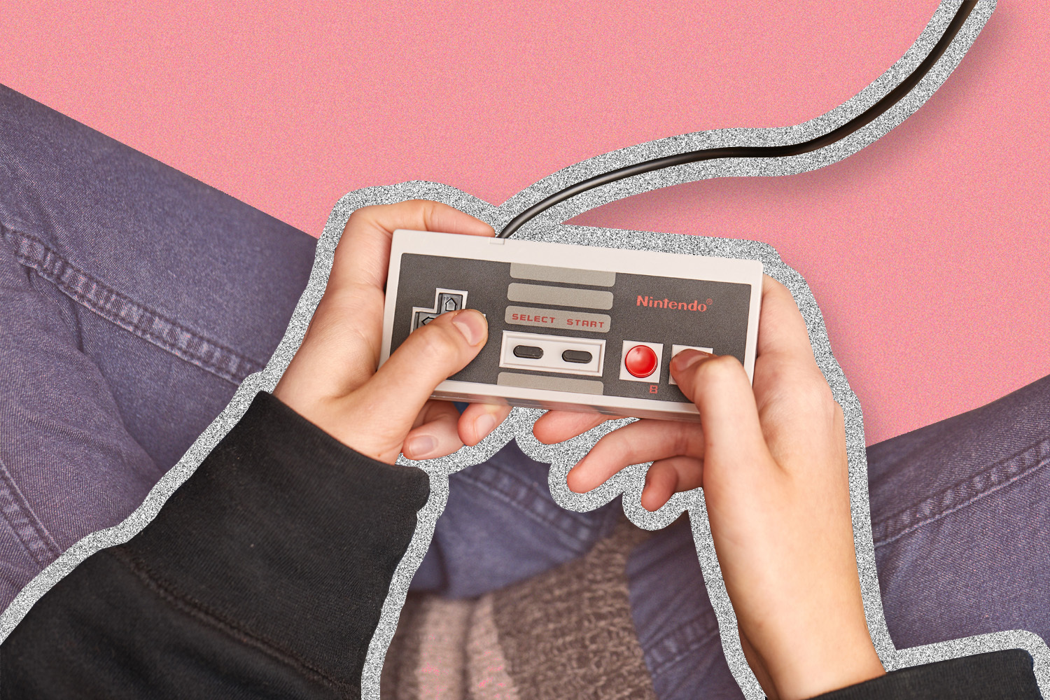 Hands holding original Nintendo console on a red background