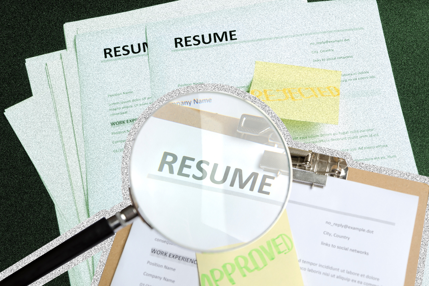magnifying glass identifying an accepted resume on a stack of rejects