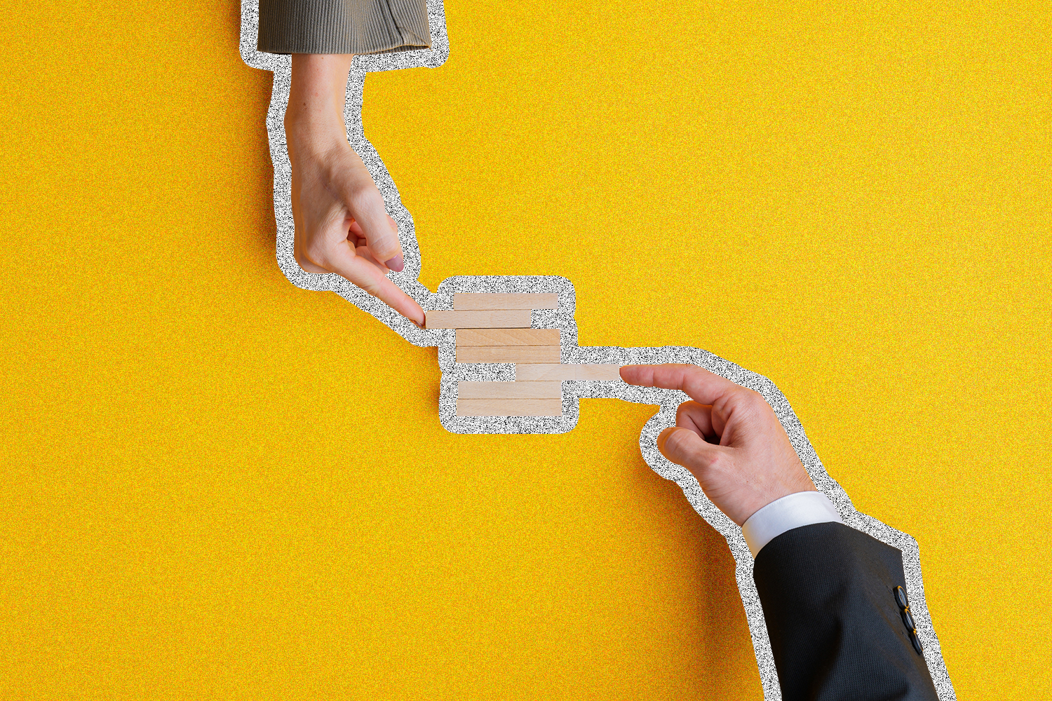 Two hands pushing wooden blocks together on a yellow background