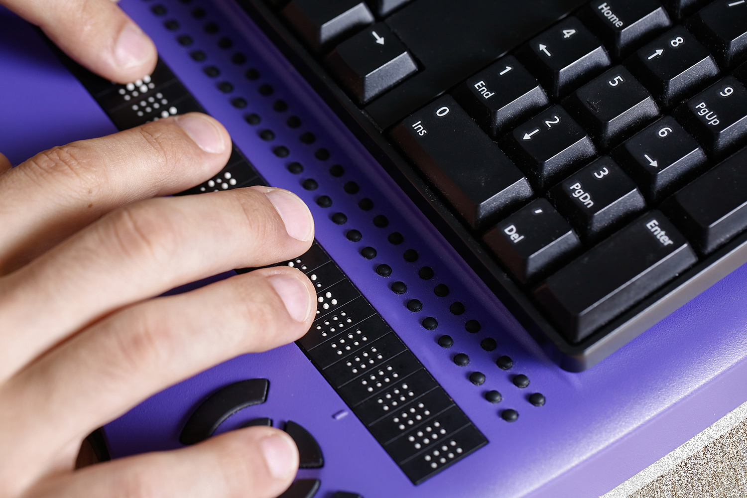 Person typing with a braille keyboard
