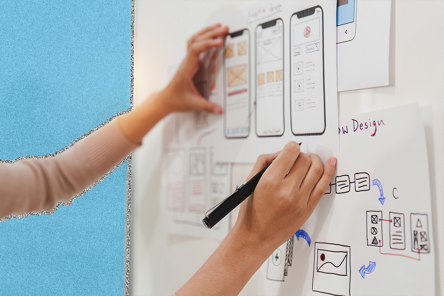 A whiteboard with mobile app designs and a person holding a pen