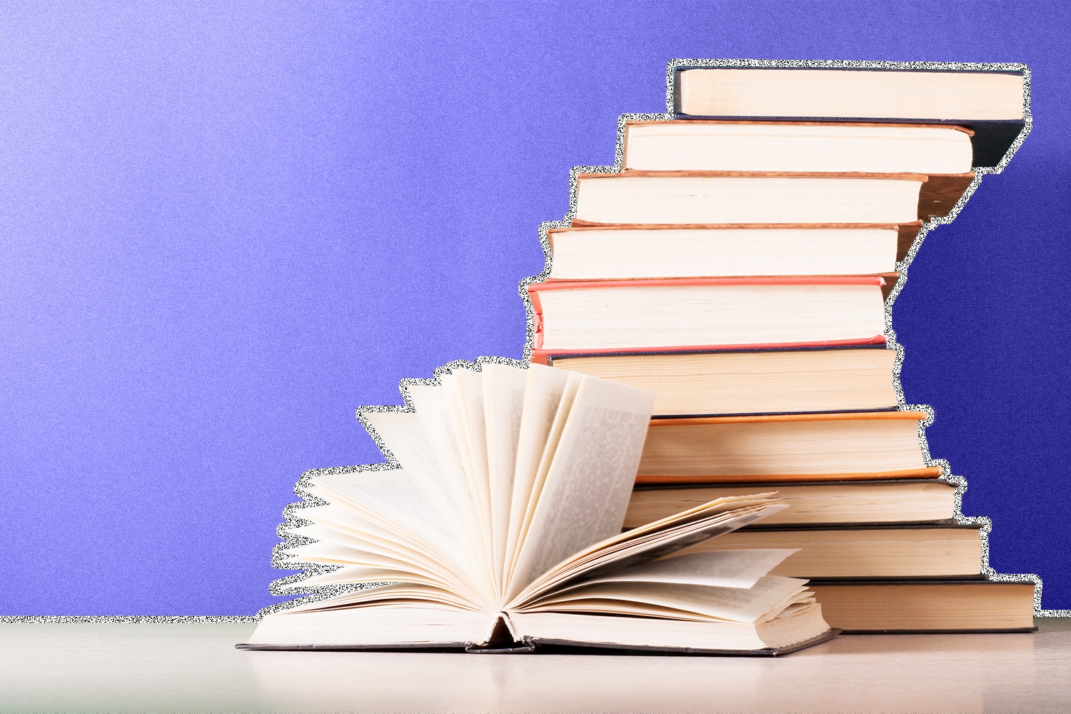 A stack of books on a table with one flipped open, on a purple background