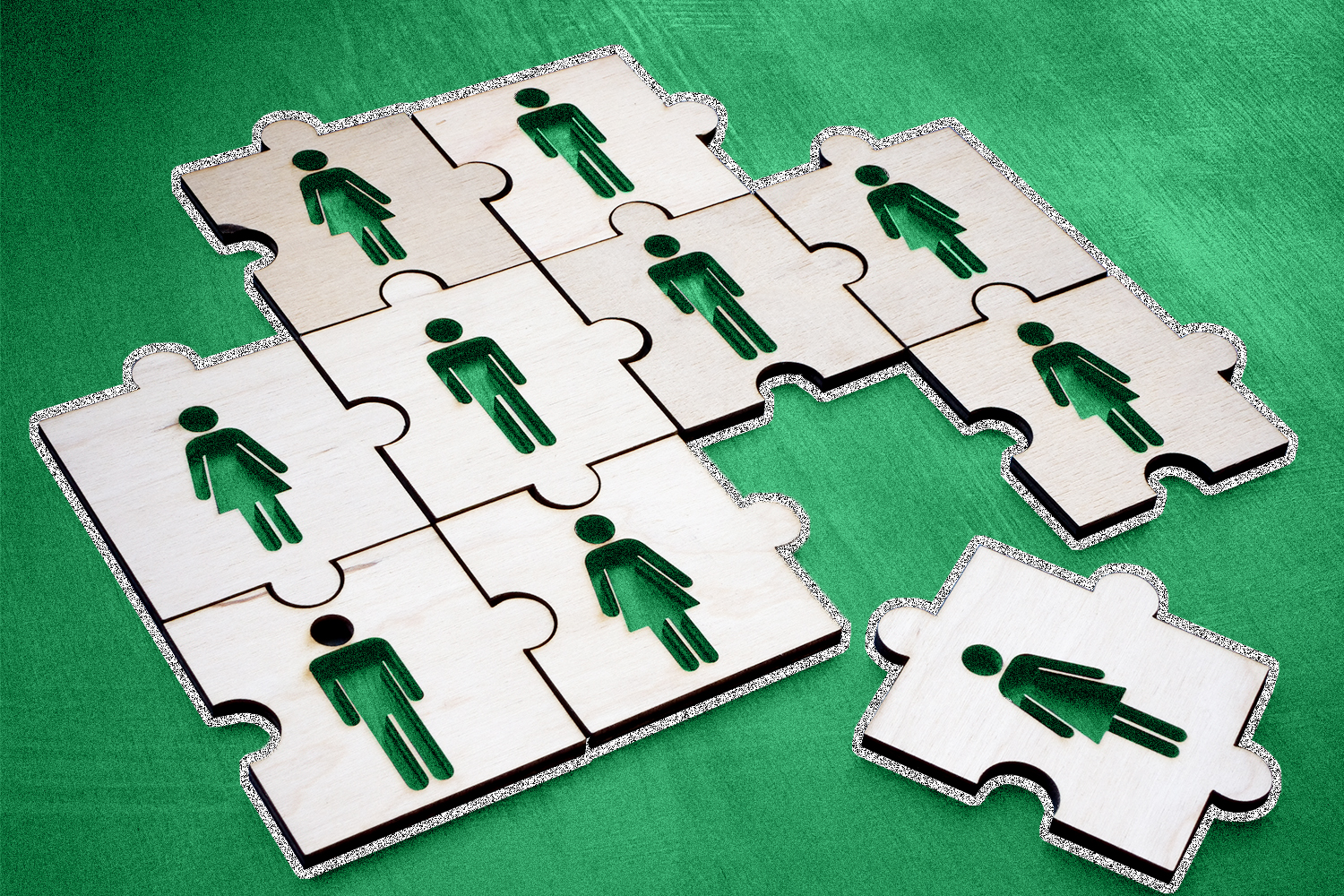 Puzzle pieces with people shapes on a green background